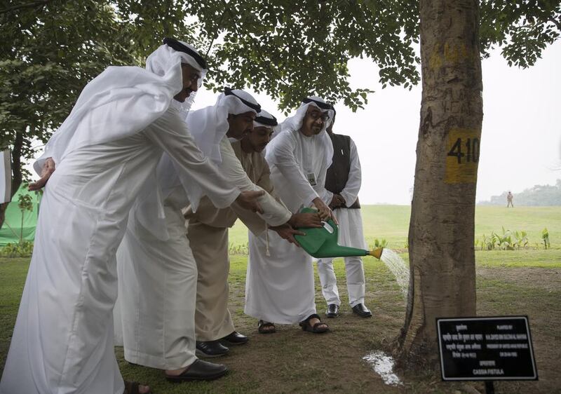 From left: Sheikh Abdullah bin Zayed, Minister of Foreign Affairs and International Cooperation, Sheikh Hamed bin Zayed, Chairman of the Crown Prince Court of Abu Dhabi, Sheikh Mansour bin Zayed, Deputy Prime Minister and Minister of Presidential Affairs, and Sheikh Mohammed bin Zayed water a tree planted by Sheikh Zayed at the Raj Ghat memorial. Mohamed Al Hammadi / Crown Prince Court - Abu Dhabi