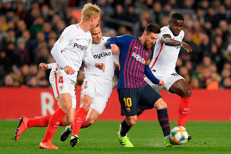 Barcelona's Lionel Messi dribbles past Sevilla's Simon Kjaer and Quincy Promes. AFP
