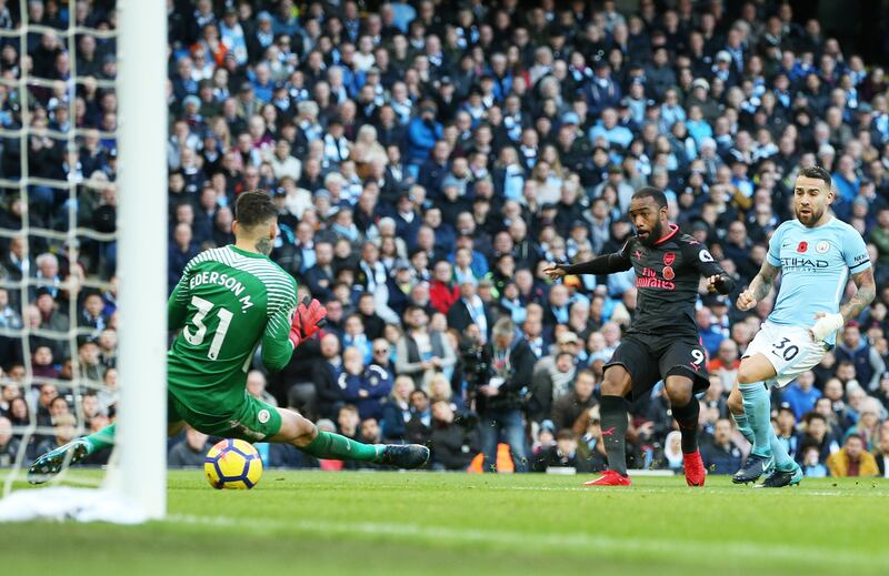 epa06310128 Alexandre Lacazette (C) of Arsenal scores his team's first goal against goalkeeper Ederson and defender Nicolas Otamendi (R) of Manchester City during the English Premier League match between Manchester City and Arsenal at the Etihad Stadium in Manchester, Britain, 05 November 2017.  EPA/NIGEL RODDIS No use with unauthorised audio, video, data, fixture lists, club/league logos 'live' services. Online in-match use limited to 75 images, no video emulation. No use in betting, games or single club/league/player publications.  EDITORIAL USE ONLY