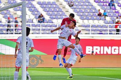 Qatar's midfielder Boualem Khoukhi (up) fights for the ball with North Korea's defender Chol Bom Kim and scores a goal during the 2019 AFC Asian Cup group E football match between North Korea and Qatar at the Khalifa bin Zayed stadium in al-Ain on January 13, 2018.  / AFP / Giuseppe CACACE
