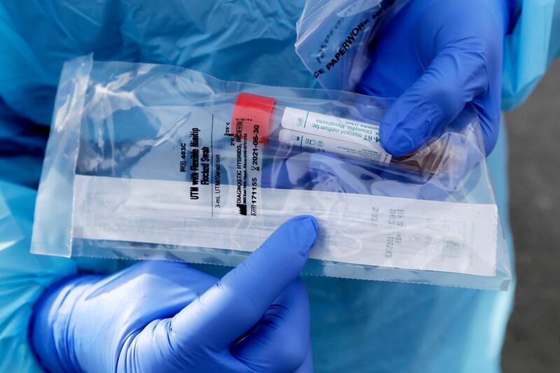 FILE - In this March 17, 2020, file photo a health worker displays the packaged nasopharyngeal swab, which goes about two inches into the nasal cavity, used on patients at a drive-through COVID-19 testing station for University of Washington Medicine patients in Seattle. A backlash roiled across social media Wednesday, March 18, as several celebrities and professional athletes revealed that they had been tested for the coronavirus, even when they didnâ€™t have a fever or other tell-tale symptoms. (AP Photo/Elaine Thompson, File)