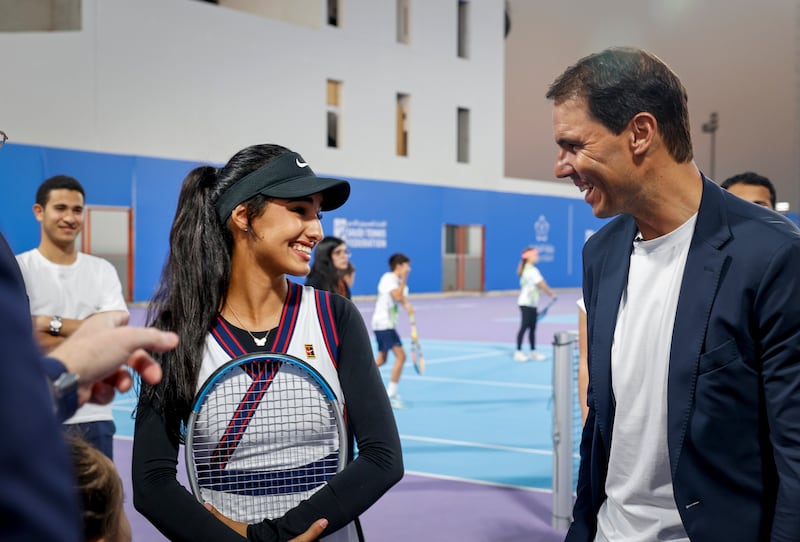 Rafael Nadal speaks to a young tennis player during a tennis clinic held at Mahd Academy.