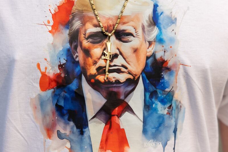 An attendee wears a necklace with a rifle pendant and a shirt featuring Donald Trump during a town hall event with Chris Christie, former governor of New Jersey, in New Hampshire, US, on June 6. Christie became the latest Republican to enter the 2024 presidential campaign. Bloomberg