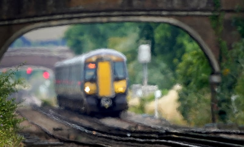 A train passes through heat haze on a railway line near Ashford in Kent. PA