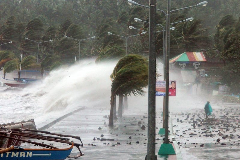 A resident walks past high waves pounding the sea wall amidst strong winds as Typhoon Haiyan hit the city of Legaspi, Albay province, south of Manila on November 8, 2013. Charism Sayat / AFP Photo