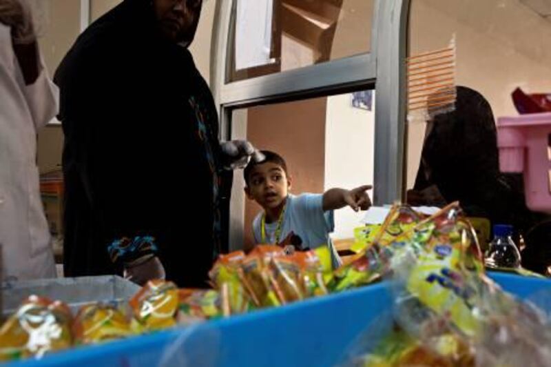 A young boy makes his choice in school's cafeteria shortly before lunch break on Thursday, April 28, 2011, at the Butti Public School in Bani Yas. The very limited choices included white-flower pasta with sauce, white-bread buns, sugary juice packs, chips, crackers, and sweets. The only fresh food was only in pictures on a plastic table cloth. (Silvia R‡zgov‡ / The National)



