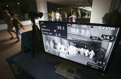 Passengers walk past a thermal scanner at the quarantine area at Manila International Airport arrivals, in the Philippines. AP photo