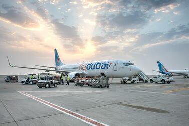 Aircraft on the ground surrounded by ground equipment and staff