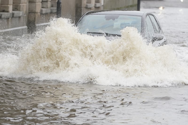 A car ploughs through floodwater on Canal Quay in Newry. PA