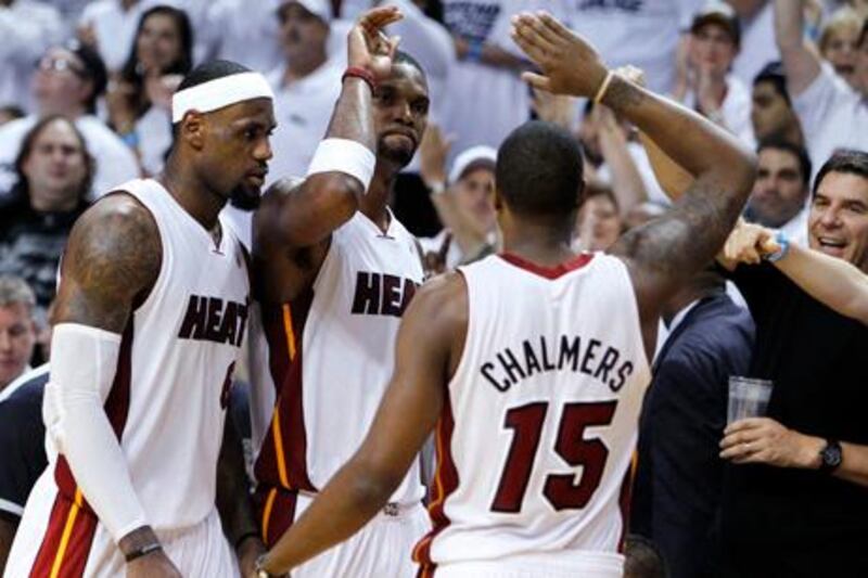 Miami Heat's Chris Bosh, center, Mario Chalmers, right, and LeBron James congratulate each other during the second half of Game 7 of the NBA basketball playoffs Eastern Conference finals against the Boston Celtics, Saturday, June 9, 2012, in Miami. The Heat defeated the Celtics 101-88. (AP Photo/Lynne Sladky)