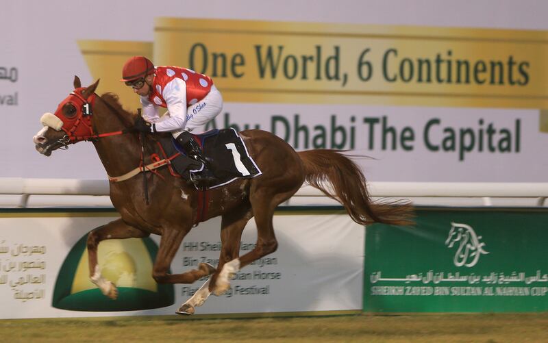 Tadhg O'Shea rides Rb Torch to the win in the Hamdan Handicap on Monday night at Abu Dhabi Equestrian Club. Ravindranath K / The National