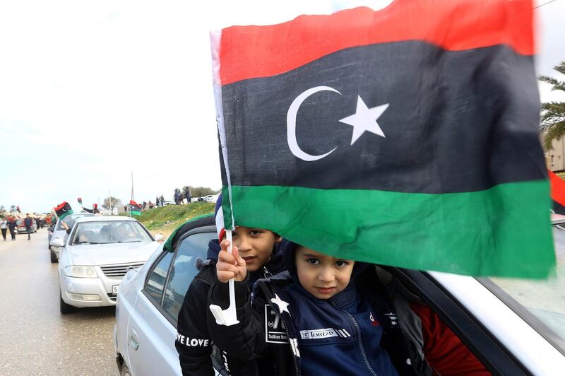 Libyan children wave their national flag in the capital Tripoli during a celebration to mark the the upcoming eight anniversary of the Libyan revolution which toppled strongman Moamer Kadhafi, on February 25, 2019. / AFP / Mahmud TURKIA
