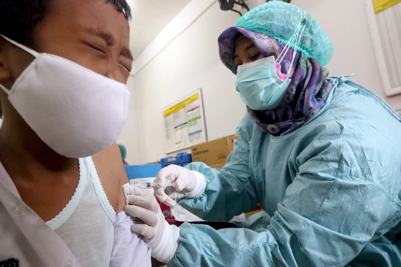 A dose of Covid-19 vaccine is given to a school pupil during a vaccination drive for children aged 6 to 11, in West Java, Indonesia. The country has reported that more than 4.2 million coronavirus infections with cases among people aged 18 and under making up 13 per cent of Indonesia’s total cases. EPA
