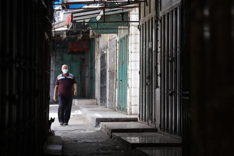 A Palestinian man walks near closed shops in an empty street in the West Bank city of Nablus.  EPA