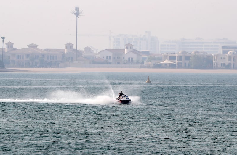 A jet ski makes its way through the water near The Palm Jumeirah in Dubai.