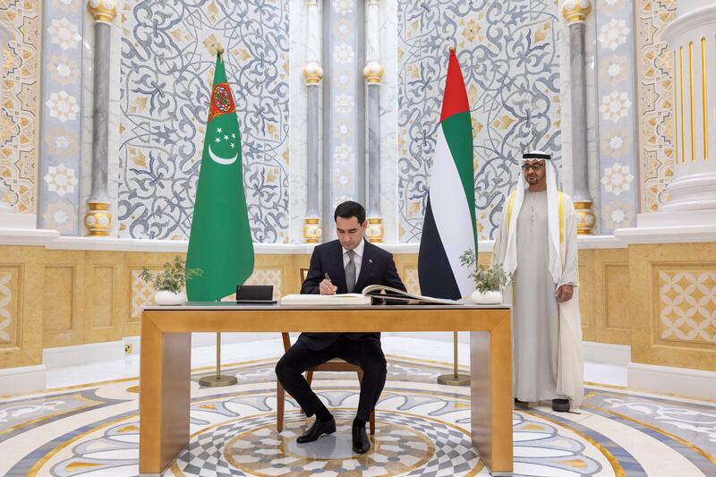 Sheik Mohamed watches Mr Berdimuhamedow sign the guest book during the reception. Photo: UAE Presidential Court 