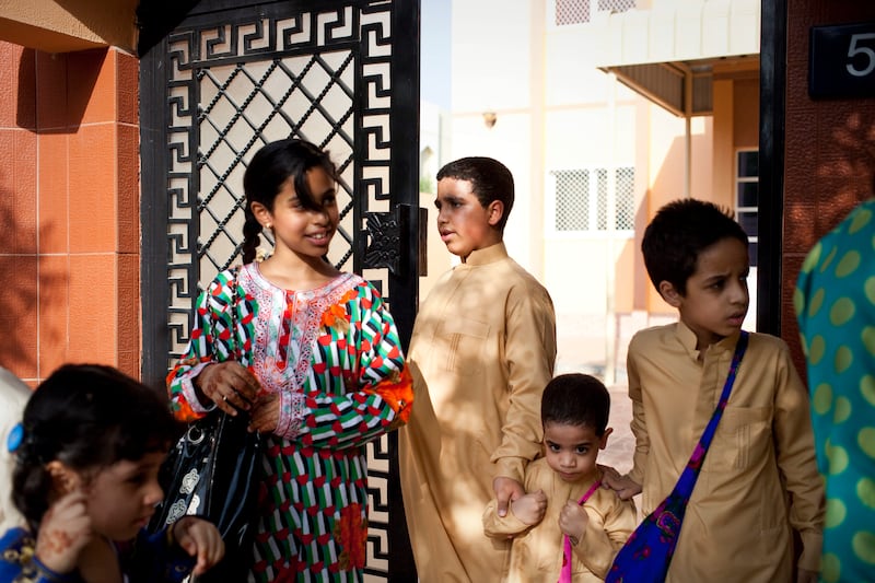 Sharjah, United Arab Emirates - June 23 2013 - (L-R) Cousins Maitha Al Jabri, Hind Al Suwaidi,10, Mohammad Al Jabri, 12, Abdulrahman Al Jabri, and Abdullah Al Jabri leave a home in the Leyyah neighborhood of the city after collecting sweets. They are participating in Hag El Leila, an Emirati tradition that occurs every year 15 days before the start of the month of Ramadan. The tradition involves children walking from door-to-door singing and collecting sweets and money. (Razan Alzayani / The National)  FOR RYM GHAZAL STORY  *** Local Caption ***  RA0623_hag_el_layla_007.jpg