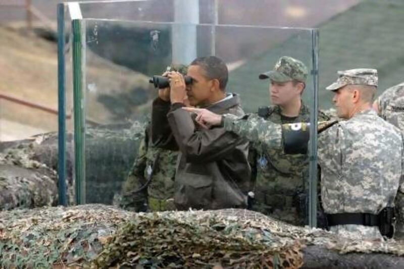 US President Barack Obama looks through binoculars to see North Korea from Observation Post Ouellette in the Demilitarised Zone, the tense military border between the two Koreas.