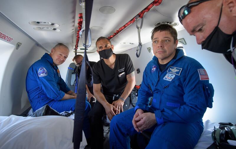 NASA astronauts Douglas Hurley (L) and Robert Behnken prepare to depart their helicopter at Naval Air Station Pensacola after the duo landed in their SpaceX Crew Dragon Endeavour spacecraft in the Gulf of Mexico off the coast of Pensacola, Florida, U.S. REUTERS