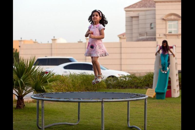 Abu Dhabi, United Arab Emirates, May 2, 2012:   
Three-year-old Judy al Enezi, jumps on a trampoline as she and her family play outside of their home in Khalifa City A neighborhood near Abu Dhabi on Tuesday evening, May 1, 2012. While the municipality plans to build three parks with playgrounds, the large residential neighborhood has none at the moment. (Silvia Razgova / The National)

