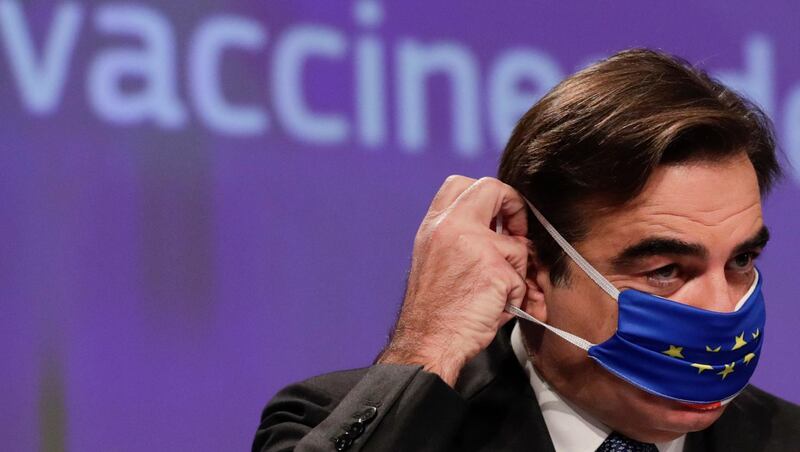 European Commissioner for Promoting our European Way of Life Margaritas Schinas puts on his face mask after a media conference on the EU's Covid-19 vaccine strategy at the bloc's headquarters in Brussels.  AP