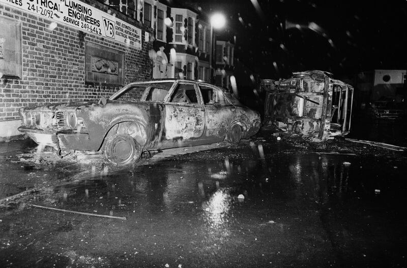 LONDON - OCTOBER 1985: (FILE PHOTO) Cars left overturned and burned-out in the street after rioting on the Broadwater Farm housing estate, Tottenham, London, 6th October 1985. The racial disorder developed after Cynthia Jarret collapsed and died as police searched her home for stolen property. Serving officer PC Keith Blakelock died after being attacked by rioters in the ensuing violence. Twenty-Six years later, riots have again broken out in Tottenham on August 6, 2011 following a demonstration protesting the police shooting of twenty-nine-year-old father-of-four Mark Duggan on August 4, 2011 who died in an exchange of gunfire while police were attempting to arrest him.  (Photo by Julian Herbert/Getty Images) *** Local Caption ***  120530731.jpg