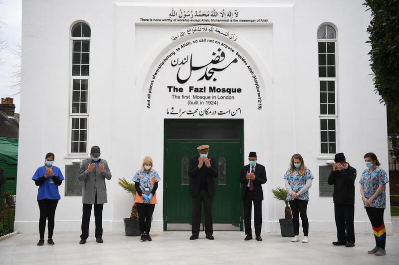 Health workers and faithful at the Fazl mosque vaccination centre take part in a minutes silence in southwest London. AFP