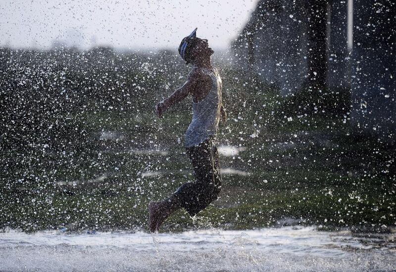 A young man cools off in the water of a leaking pipeline during a heat wave in Karachi, Pakistan.  Asif Hassan / AFP