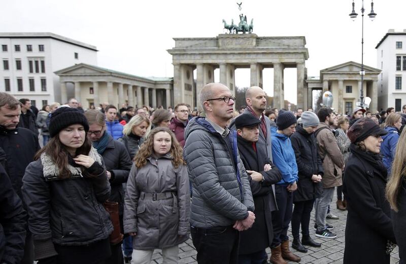 People stand still during a minute of silence at the Brandenburg Gate in Berlin, Germany, on November 16, 2015, to honour the victims of the terrorist attacks in France Michael Sohn / Associated Press