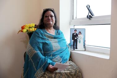 Priscilla Aden sits with a photo of her late husband at her home in Sharjah. Pawan Singh / The National