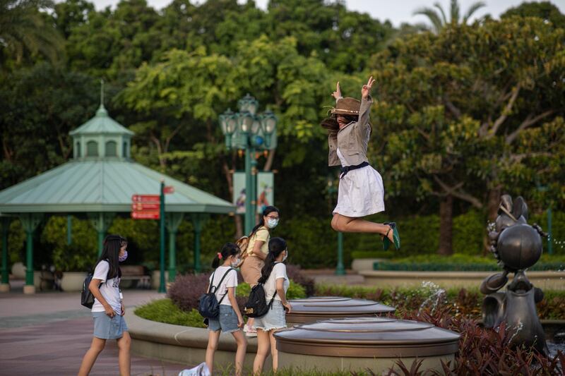 A visitor jumps for photographs in Disneyland in Hong Kong, China. The theme park will shut its doors until July 21, 2020 due to a surge in Covid-19 cases in Hong Kong.  EPA