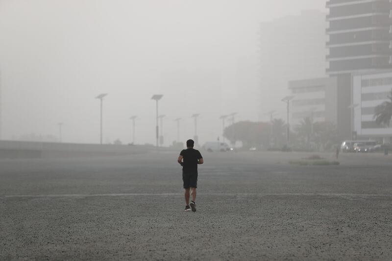 A lone runner ventures out during hazy weather in Dubai. Chris Whiteoak / The National
