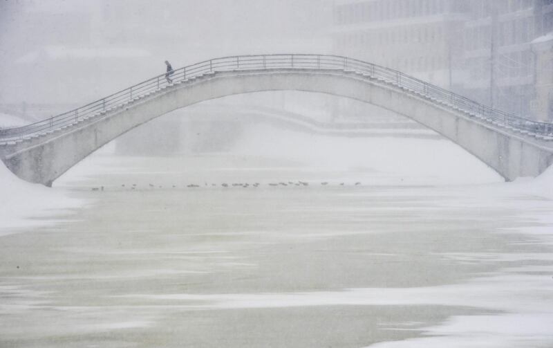 A man crosses a bridge during a snowfall in Moscow. Olga Maltseva / AFP Photo