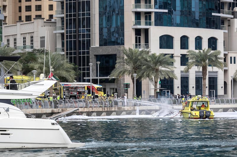 DUBAI, UNITED ARAB EMIRATES. 24 JANUARY 2020. Civil Defense extinguise the remains of a yacht that burnt out in the Dubai Marina. (Photo: Antonie Robertson/The National) Journalist: None. Section: Sport.

