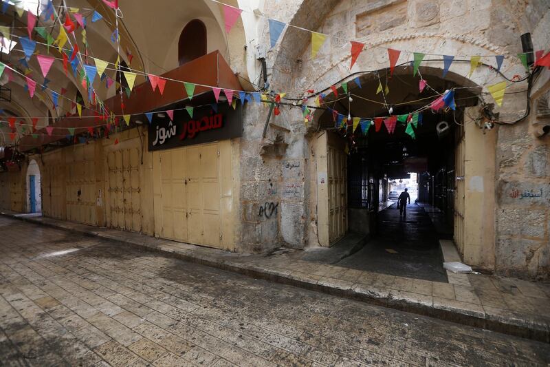 A Palestinian man walks in an empty street during a general strike in the West Bank city of Nablus, May 18. EPA