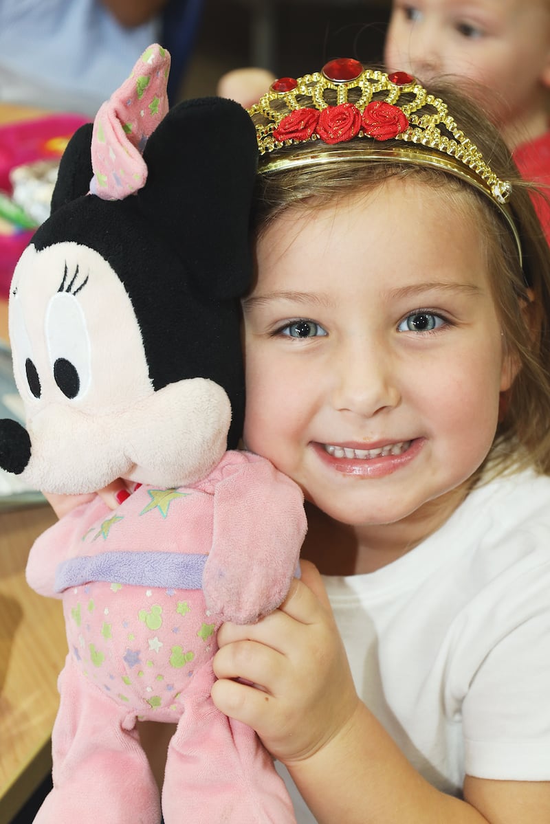A pupil at the school poses with a Minnie Mouse stuffed toy as she celebrates the queen's platinum jubilee this year. 