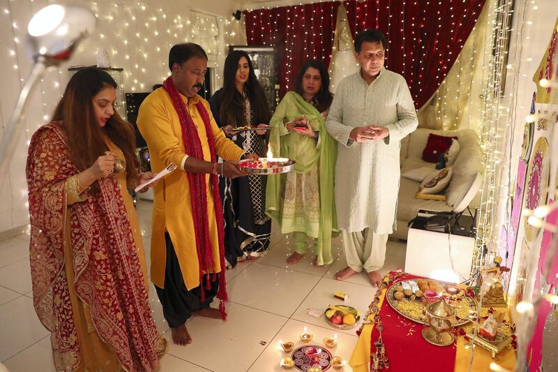 DUBAI, UNITED ARAB EMIRATES , November 14 – 2020 :- Left to Right - Rajni Ghosh, Amit Ghosh, Oshin Kanwar, Romi Kanwar and Ashish Kanwar  doing prayers on Diwali festival at Al Furjan in Dubai. Diwali is the Indian festival of lights. People do prayers and exchange gifts and sweets on this day. (Pawan Singh / The National) For News/Standalone/Online/Instagram/Big Picture