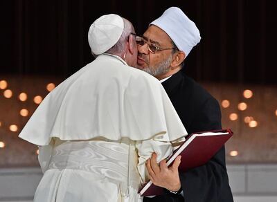 Pope Francis (L) and Egypt's Azhar Grand Imam Sheikh Ahmed al-Tayeb greet each other as they exchange documents during the Human Fraternity Meeting at the Founders Memorial in Abu Dhabi on February 4, 2019. Pope Francis rejected "hatred and violence" in the name of God, on the first visit by the head of the Catholic church to the Muslim-majority Arabian Peninsula. / AFP / Vincenzo PINTO                      
