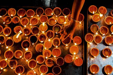 A Hindu devotee holds an oil lamp while offering prayers during Diwali, the festival of lights, at a Hindu temple in Colombo on November 4, 2021.  (Photo by ISHARA S.  KODIKARA  /  AFP)