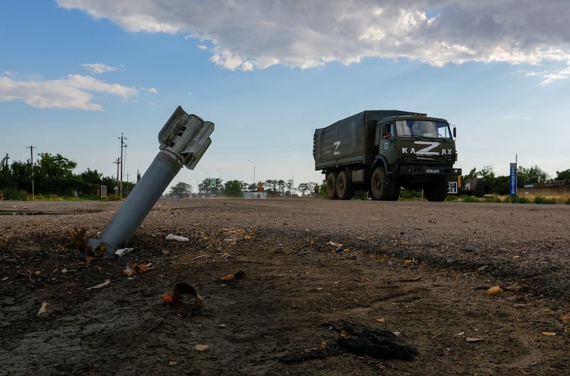 A Russian military lorry drives past an unexploded munition in the village of Chornobaivka, in the Kherson region. Reuters