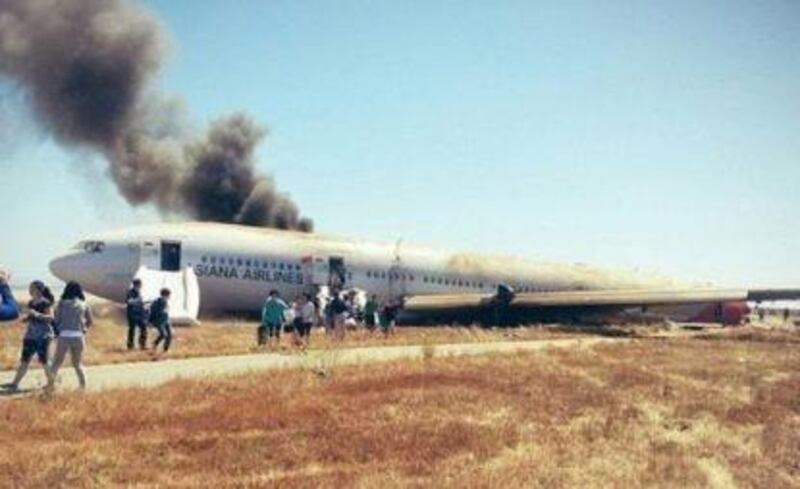 epa03778885 A photo of the Asiana Airlines passenger jet that crashed at San Francisco International Airport, San Francisco, California, USA, on  06 July 2013. The photo was taken by one of the passengers soon after he escaped from the scene. The Federal Aviation Administration said two passengers were killed and dozens of others injured. The Boeing 777 plane, which departed from Incheon International Airport near Seoul, was carrying 307 passengers and crew members, of which 77 were South Koreans, 141 Chinese and 61 Americans. The FAA said 48 people were transferred to nearby hospitals, adding the ill-fated plane may have collided with something after it landed on the runway's threshold.  EPA/YONHAP SOUTH KOREA OUT *** Local Caption ***  03778885.jpg