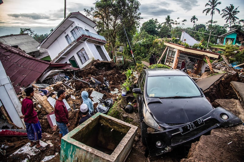 Villagers salvage items from damaged houses in Cianjur. AFP