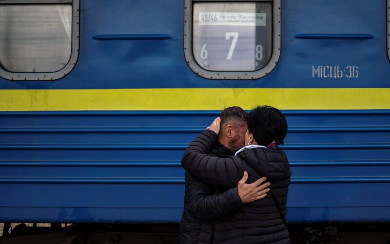 A man embraces his wife as she prepares to board a train at Slovyansk central station in the Donbas region. AFP
