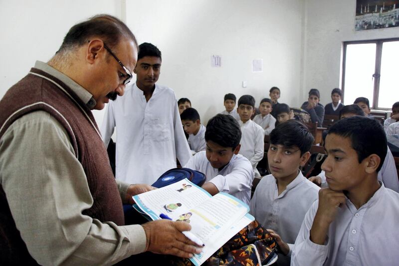 A government school teacher, Mohammad Alam, 48, teaches his class in a newly-built classroom in Ahingaro Dherai village of militancy-hit Swat district in Pakistan‚Äôs Khyber Pakhtunkhwa province. Aamir Saeed for The National