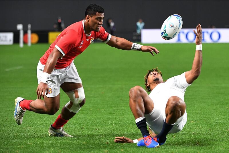Tonga wing Viliami Lolohea, left, vies for the ball with England's wing Anthony Watson during the Pool C match at the Sapporo Dome. AFP