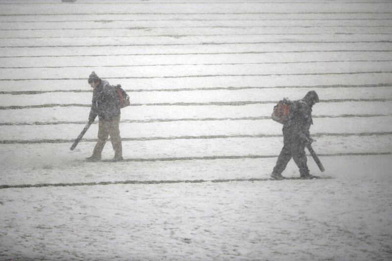 Workers use snowblowers to try to clear the field in Philadelphia on Sunday. Matt Rourke / AP