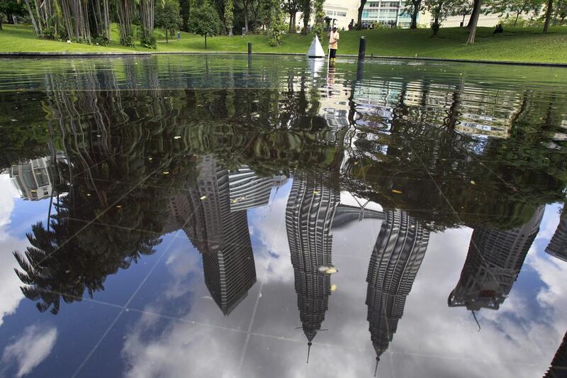 A worker cleans the pool at KLCC park in Kuala Lumpur, Malaysia. KLCC park is a 50-acre garden set close to Suria KLCC shopping centre and it was designed to provide a touch of greenery for the Petronas Twin Towers and the areas surrounding it. Daniel Chan / AP Photo