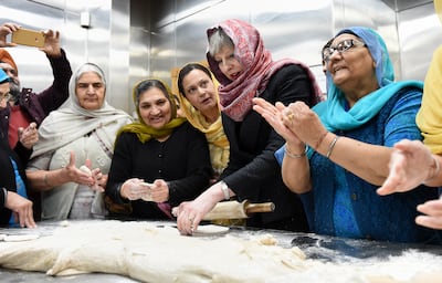 Former British Prime Minister Theresa May helps with food preparation during her visit to a Gurdwara to mark Vaisakhi, on April 11, 2018 in Walsall, England. WPA Pool/Getty Images