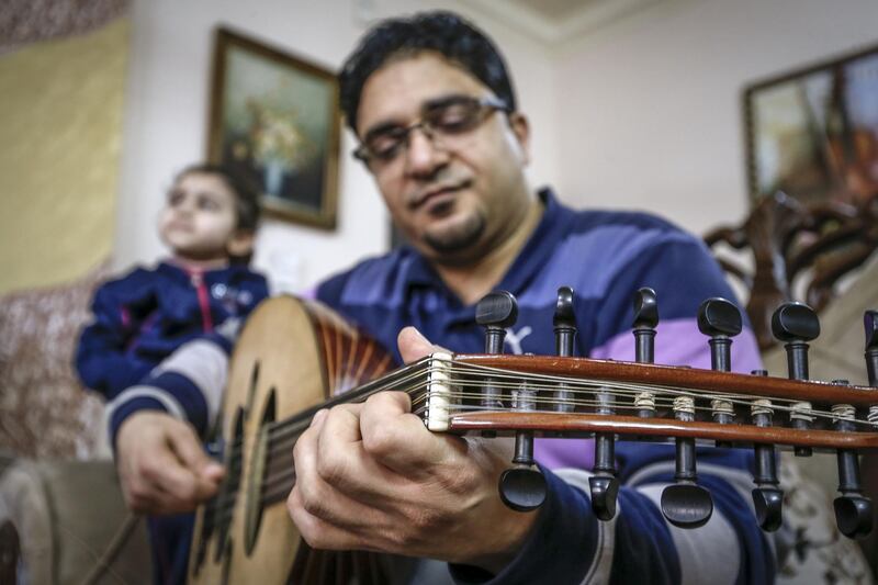Palestinian music instructor Esmail Dawood gives an online Oud lesson attended by his children, during confinement at home due to the COVID-19 outbreak, in Gaza City. AFP