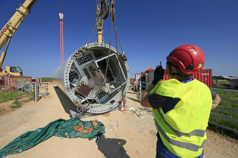 France's energy bill reached €66 billion in 2013, down 4.6 per cent from a record high the previous year, due to lower oil and coal prices. Above, a tower section of an E-70 wind turbine being readied to be lifted by a crane during its installation at a wind farm in Meneslies. Benoit Tessier / Reuters